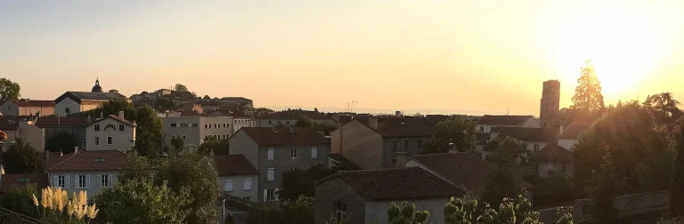 Panorama de Montbrison au crépuscule : toits de tuiles, flèche de la collégiale et ville vieille sur sa butte
